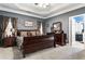 Main bedroom with a large sleigh bed, double doors, and an ensuite bathroom at 501 Holly Hills Ln, Mcdonough, GA 30252