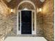 Front door entrance with a black door and arched window at 129 Talon Pl, Mcdonough, GA 30253