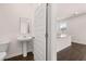 Clean bathroom with pedestal sink and view of kitchen at 524 Vervain Dr, Locust Grove, GA 30248