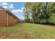 Side yard view showing a brick home, deck and large green space at 3569 Briar Dr, Lithia Springs, GA 30122