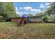 Home's back features a deck, stairs, and a spacious grassy yard at 3569 Briar Dr, Lithia Springs, GA 30122