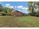 Large backyard with a mostly flat, grassy area and trees in the background at 3569 Briar Dr, Lithia Springs, GA 30122