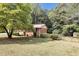 Large backyard with lush green grass, mature trees, and a shed at 3569 Briar Dr, Lithia Springs, GA 30122