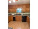 L-shaped kitchen with wood cabinets and laminate countertops at 1468 Flippen Rd, Stockbridge, GA 30281