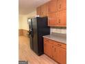 Kitchen features wood cabinets, laminate countertops, and black appliances at 1468 Flippen Rd, Stockbridge, GA 30281