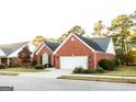 Brick ranch home with a two-car garage and landscaped yard at 320 Crossroads Dr, Social Circle, GA 30025