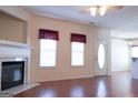 Bright living room features a fireplace, hardwood floors, and two windows with window treatments at 110 Emily Park, Fayetteville, GA 30215
