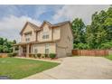 Two story house with tan siding and a driveway at 445 Brickstone Way, Covington, GA 30016