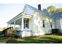 Side view of white farmhouse with a porch and landscaping at 10 Maranatha Rd, Mcdonough, GA 30252