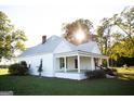 White farmhouse with a front porch, landscaping, and large yard at 10 Maranatha Rd, Mcdonough, GA 30252