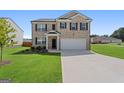 Two-story brick home with a two-car garage and a well-manicured lawn at 104 Montgomery Dr, Stockbridge, GA 30281