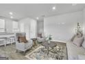 Bright living room with comfy seating, stylish rug and a view into the kitchen at 114 Jacoby Dr # 111, Fairburn, GA 30213