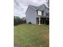 Side view of a gray two-story house with fenced backyard at 25 Franklin Way, Covington, GA 30016