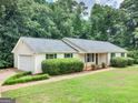 Ranch house with light-colored siding, attached garage, and well-manicured lawn at 237 Mandy Ct, Mcdonough, GA 30252