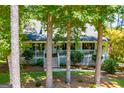 House nestled among tall trees, showcasing a large front porch at 4194 Argonne Dr, Villa Rica, GA 30180