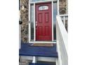 Red front door with stone and glass accents at 3870 Michaels Creek Ct, Loganville, GA 30052