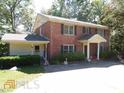 Two-story brick home with covered entry and landscaping at 573 Lester Rd, Fayetteville, GA 30215
