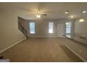 Spacious living room with neutral carpet, ceiling fan, and access to kitchen at 5780 Grande River Rd, Atlanta, GA 30349