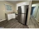 Modern kitchen with white cabinets, granite countertops, stainless steel appliances, and vinyl flooring at 3207 Cloverhurst Dr, East Point, GA 30344