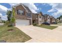 Townhouse-style home with attached garage and manicured lawn at 1705 Labonte Pkwy, Mcdonough, GA 30253