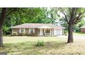 Brick ranch house with a covered porch and mature trees at 140 Grove Creek Dr, Locust Grove, GA 30248