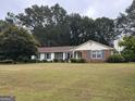 Ranch style home with brick facade and spacious lawn at 241 Lariat Ln, Ellenwood, GA 30294