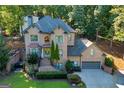 Two-story brick home with landscaping and a three-car garage at 3125 Carlton Rd, Cumming, GA 30041