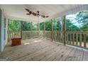 Spacious front porch with wooden flooring and railing at 2 Poplar St, Porterdale, GA 30070
