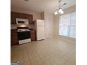 Kitchen features wood cabinets, white appliances, and a breakfast area at 2103 Grove Way, Hampton, GA 30228
