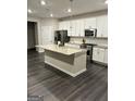 Modern kitchen with island, stainless steel appliances, and granite countertops at 4020 Red Canoe Bnd, Lilburn, GA 30047