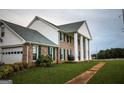 Side view of brick house with white columns, green shutters, and attached garage at 1530 Highway 11, Mansfield, GA 30055