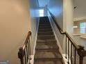 Staircase with wooden railing leading to the second floor at 308 Rankin Cir, Mcdonough, GA 30253