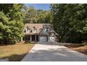 Two-story house with a brick facade and a two-car garage, nestled in a wooded area at 5447 Centry Dr, Villa Rica, GA 30180