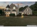 Two-story house with a wrap-around porch at dusk at 800 Clover Dr, Social Circle, GA 30025