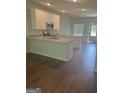 Modern kitchen with white cabinets, granite countertops, and dark hardwood floors at 1921 School House Ln, Temple, GA 30179