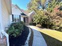 Landscaped front yard with walkway leading to house entrance at 938 Mulberry Fields Cv, Auburn, GA 30011