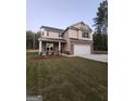 Two-story house with tan siding and a white garage door at 200 Parker Dr, Mcdonough, GA 30253
