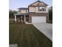 Two-story house with tan siding and a white garage door at 200 Parker Dr, Mcdonough, GA 30253