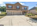 Two story house with three car garage and landscaped yard at 8069 Louis Dr, Locust Grove, GA 30248