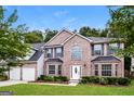 Two-story brick home with a two car garage and manicured lawn at 661 Tomahawk Pl, Austell, GA 30168