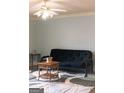 Living room featuring a futon, coffee table, and ceiling fan at 12 Intown Pl, Fayetteville, GA 30214