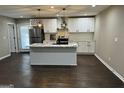 Modern kitchen with island, white cabinets, and dark floors at 1901 Maywood Nw Pl, Atlanta, GA 30318