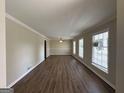 Bright living room featuring hardwood floors, crown molding, and large windows at 3107 Cherry Blossom Ln, East Point, GA 30344