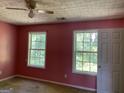 Bright bedroom with two windows and a ceiling fan at 715 Hennepin Ter, Mcdonough, GA 30253