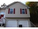 Tan two-story house with red accents and attached garage at 6995 Pine Shadow Way, Winston, GA 30187