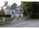 Tan two-story house with red door and attached two-car garage at 6995 Pine Shadow Way, Winston, GA 30187