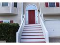 Front entry with red door and white steps leading to house at 6995 Pine Shadow Way, Winston, GA 30187
