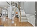 Bright entryway with hardwood floors, elegant staircase, and views into the living room at 684 Brooks Woolsey Rd, Brooks, GA 30205