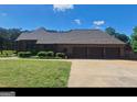 Brick ranch home with three-car garage and landscaped yard at 7866 Hwy 54, Sharpsburg, GA 30277