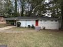 Ranch-style home with white brick exterior, landscaped lawn, and a red front door at 1370 David Cir, Decatur, GA 30032